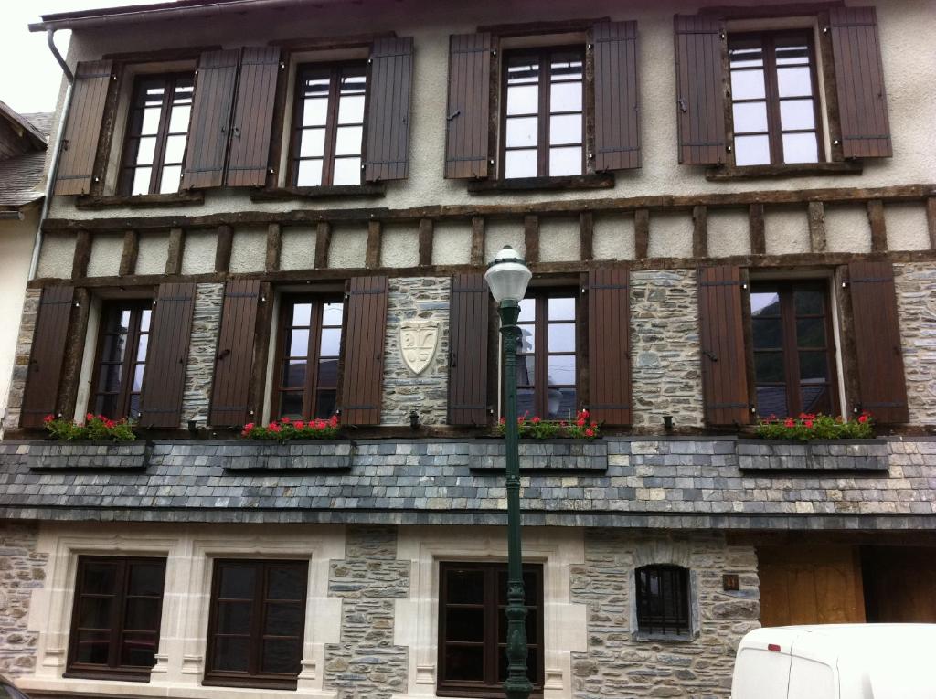 een gebouw met ramen en bloembakken erop bij Au Chant Des Marmites in Saint-Lary-Soulan