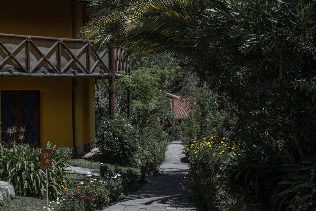 un sentiero nel giardino accanto a una casa con una palma di Andean Wings Valley a Urubamba