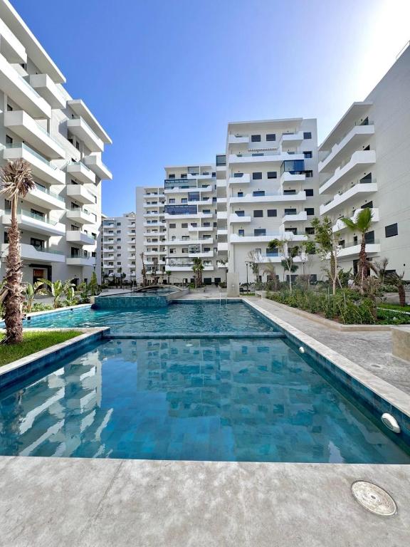 a swimming pool in front of some apartment buildings at Appartement a zenata ain-harrouda casablanca in Mohammedia