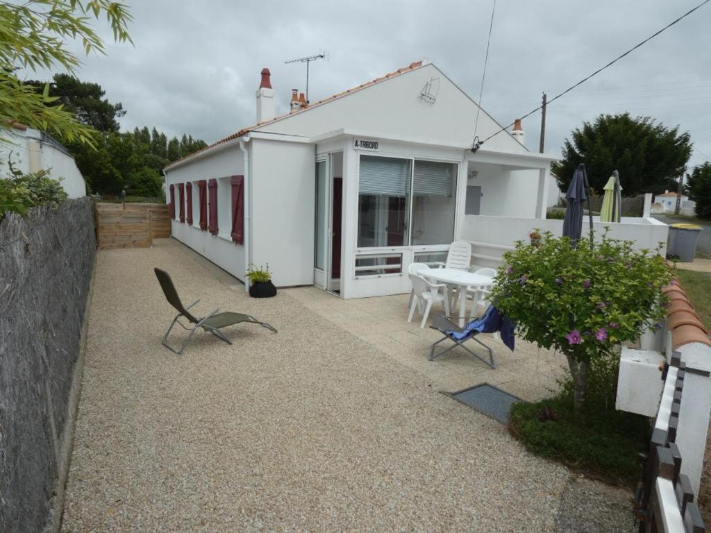 une petite maison blanche avec une table et des chaises dans l'établissement Maison de vacances à Notre-Dame-de-Monts - 4 pers, proche forêt, terr., animaux OK - FR-1-540-281, à Notre-Dame-de-Monts