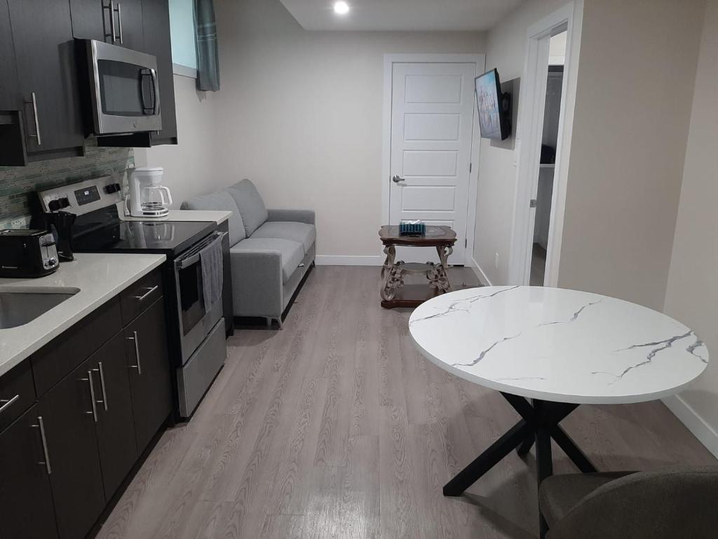 a small kitchen with a table and a couch at PineOrange Home in Saskatoon