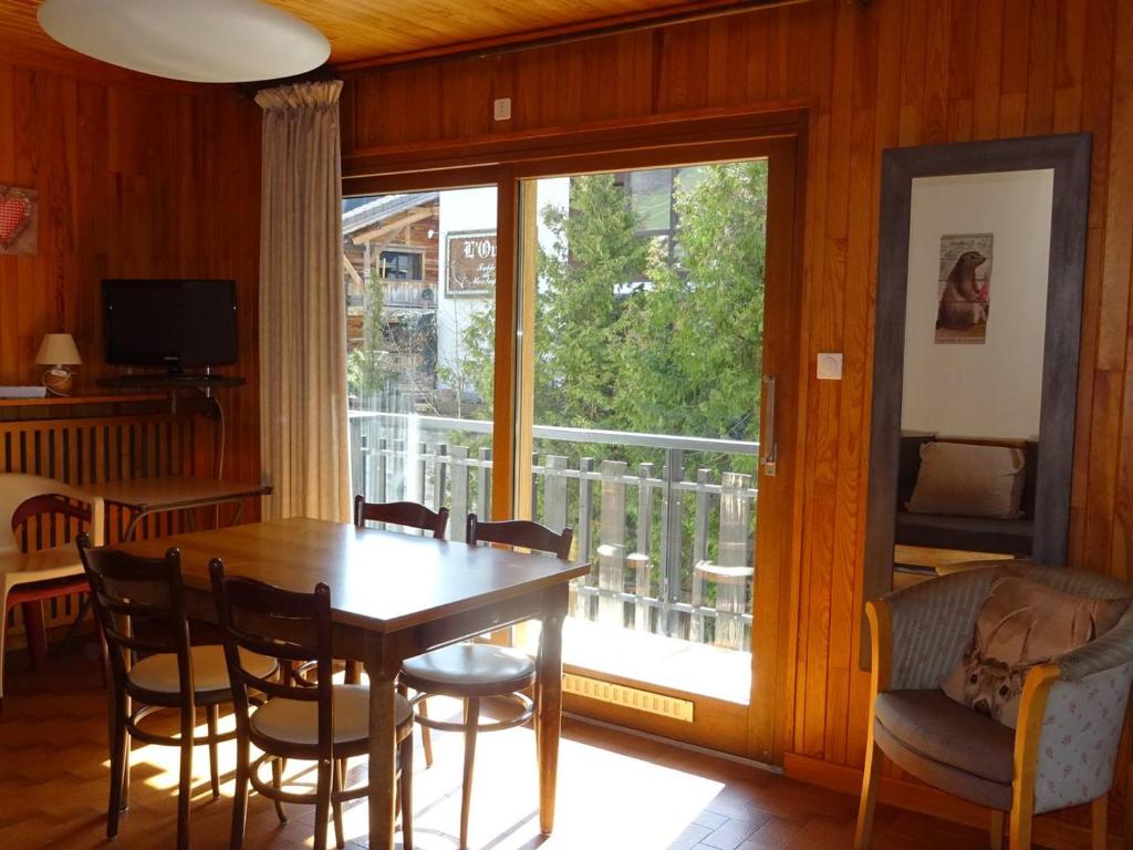 une salle à manger avec une table et un balcon dans l'établissement Spacieux 2 Pièces au Cœur des Gets - 4 Pers, Balcon, Wifi, Draps et Serviettes Offerts - FR-1-802-47, aux Gets