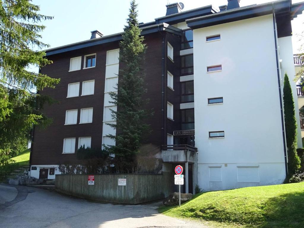 un bâtiment avec un arbre sur son côté dans l'établissement Appartement cosy 2 pièces aux Gets - 3 pers - Garage - Proche pistes et navette - FR-1-802-20, aux Gets