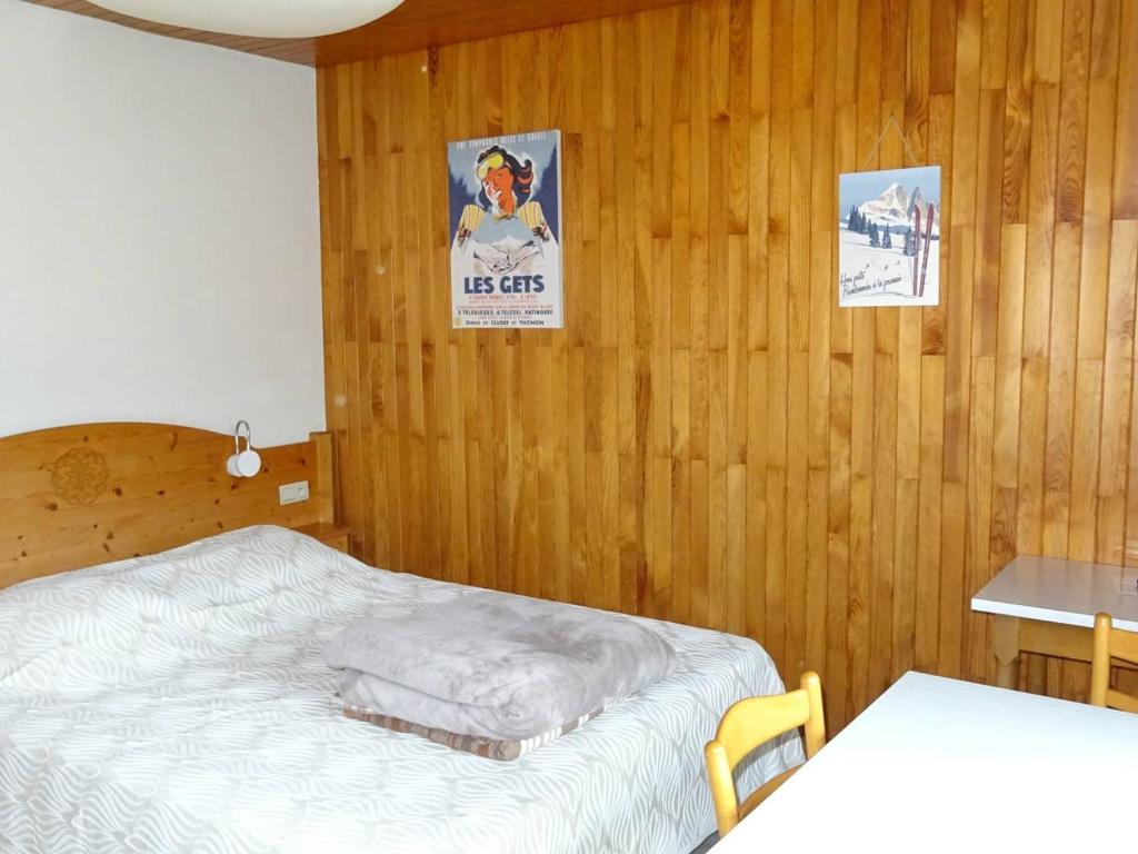 - une chambre avec un lit et deux affiches sur le mur dans l'établissement Studio cosy Les Gets - Centre, 2 pers, Wi-Fi, Draps & Serviettes Inclus - FR-1-802-29, aux Gets