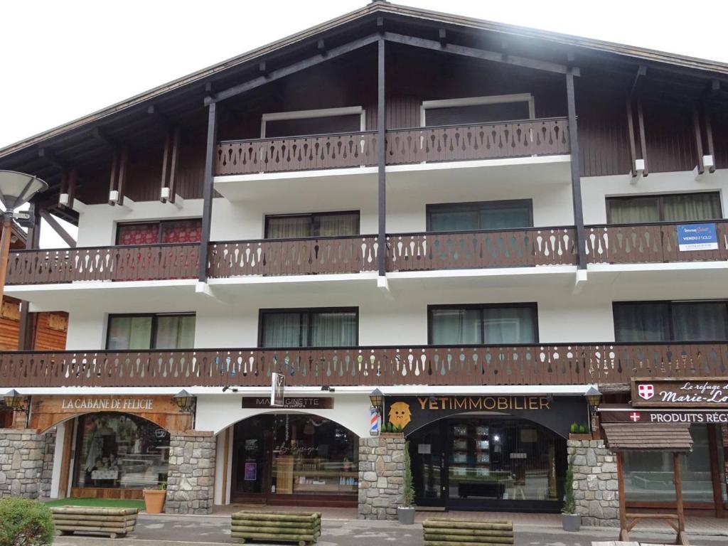 un bâtiment avec un balcon au-dessus dans l'établissement Studio cosy, lumineux au centre des Gets, 4 pers, balcon, proche pistes (100m), commerces à pied. - FR-1-802-44, aux Gets