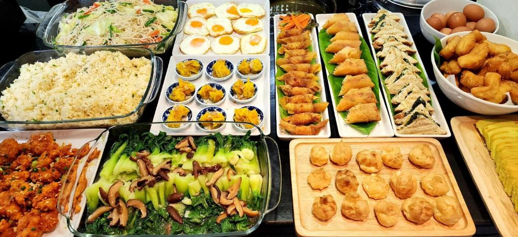A buffet spread of rice, noodles, vegetables, eggs, and pastries.