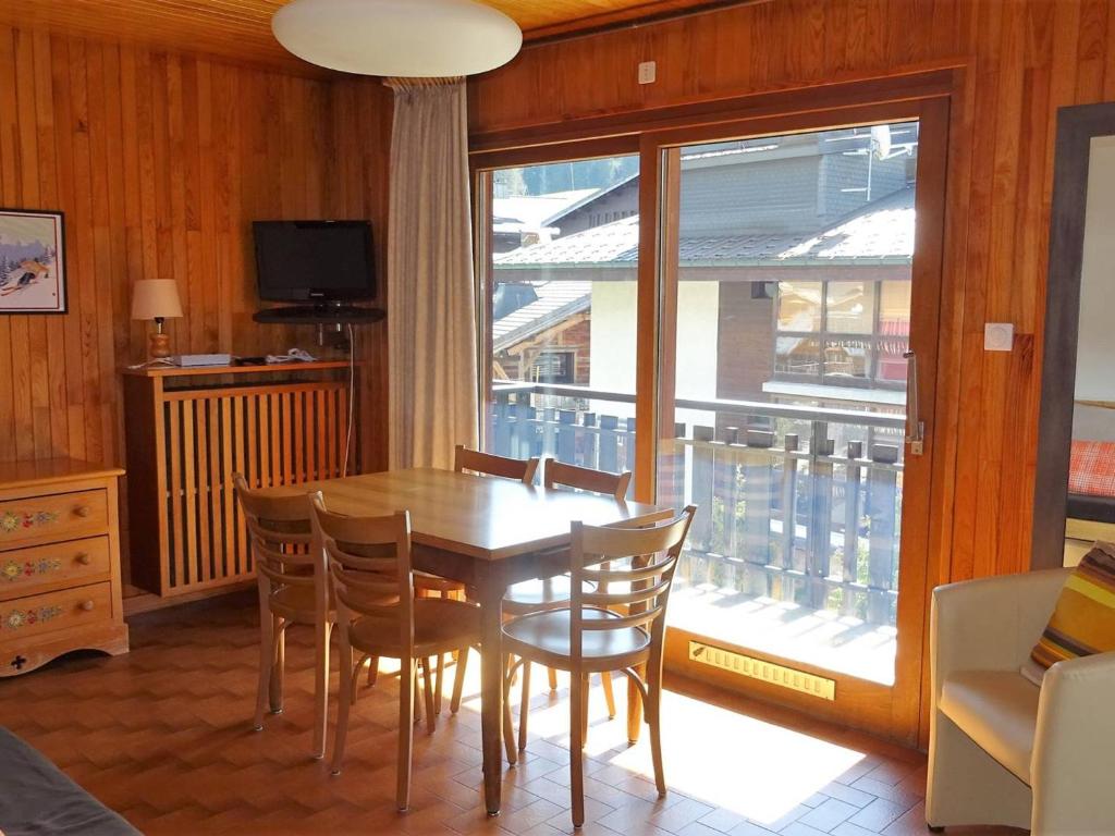 une salle à manger avec une table et des chaises et une fenêtre dans l'établissement Spacieux 2 Pièces au Coeur des Gets - 4 Pers - Balcon, WiFi, Draps et Serviettes Inclus - FR-1-802-53, aux Gets