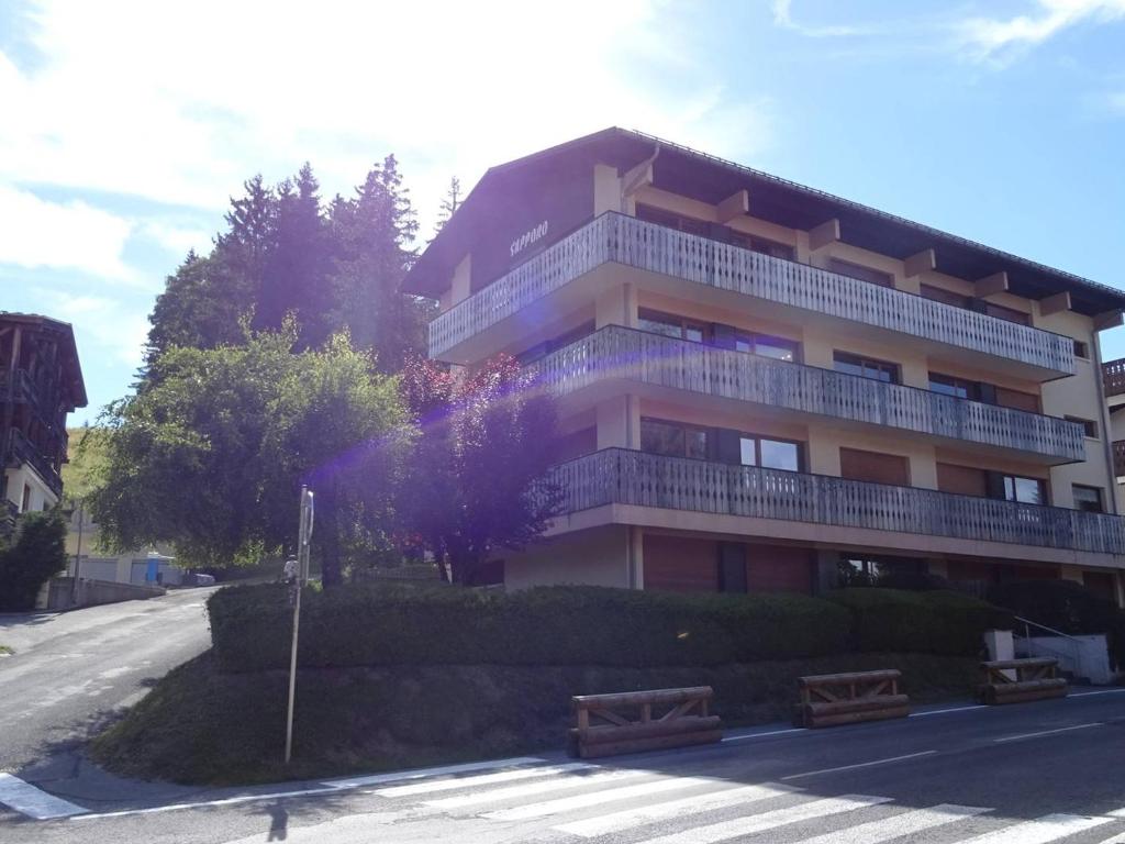 un grand bâtiment avec un balcon sur le côté d'une rue dans l'établissement Location 2P aux Gets, 5 pers., accès pistes, garage, à 300m des commerces - FR-1-802-56, aux Gets