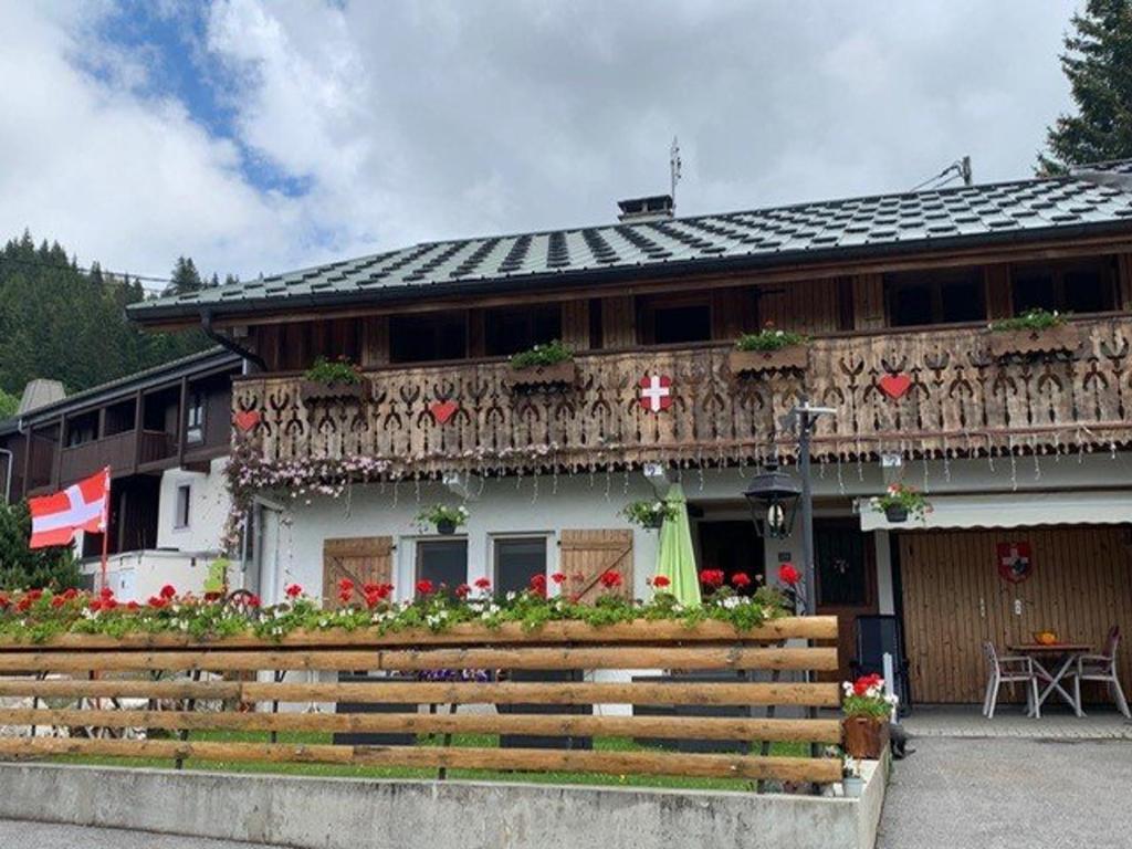 - un bâtiment avec un balcon et une table en face dans l'établissement Les Gets - Appartement 3 Pièces - 7 Pers - 100m Télésiège - Wifi - Parking - FR-1-802-85, aux Gets