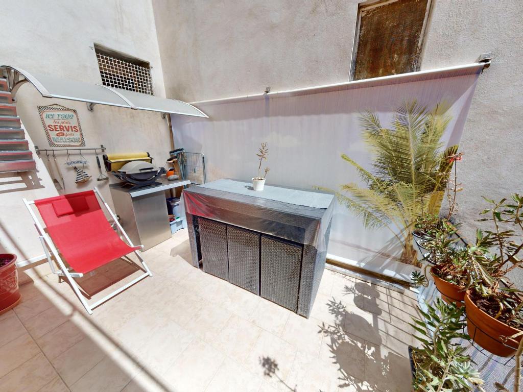 a kitchen with a table and a red chair at Appartement moderne 3 chambres, terrasse, proche plage et commerces - FR-1-785-12 in Mèze