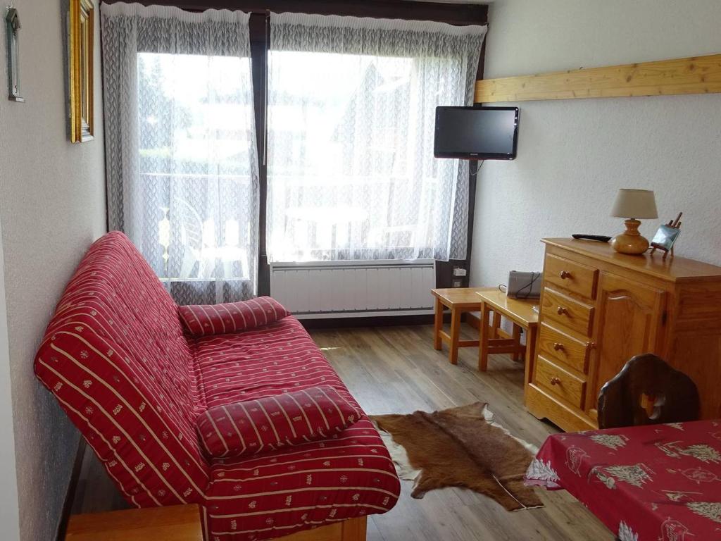 un salon avec une chaise rouge et une télévision dans l'établissement Studio Cabine Confortable 4 Pers., Centre des Gets, Proche Commerces et Pistes - FR-1-802-78, aux Gets