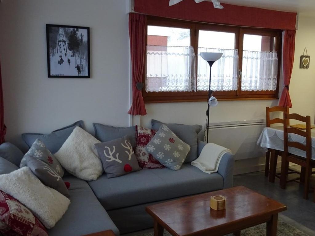 un salon avec un canapé bleu avec des oreillers dans l'établissement Les Gets - 3 Pièces Confort - 6 Pers - Arrivée Skis - WIFI - 250m Commerces - FR-1-802-89, aux Gets