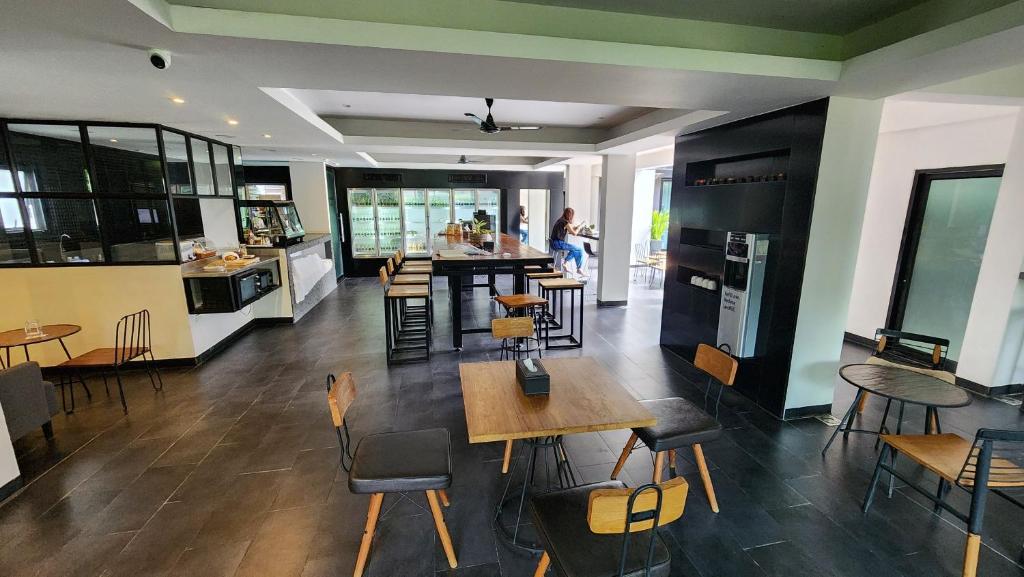 An open dining room with communal tables and a visible kitchen or service area.