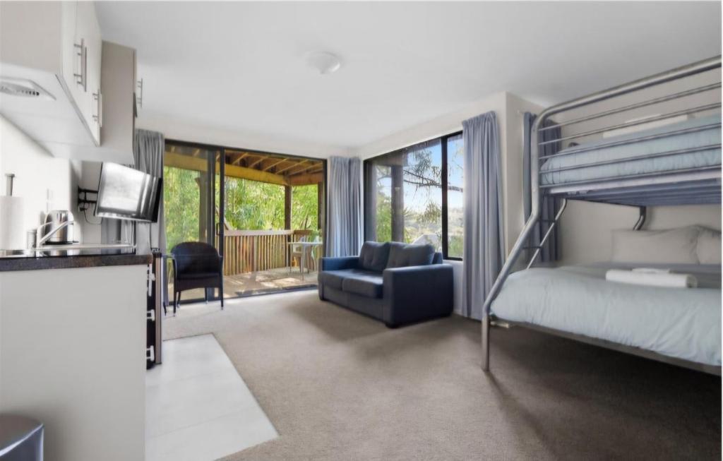 Un dormitorio con una litera y una sala de estar. en Bushview Retreat, en Paihia