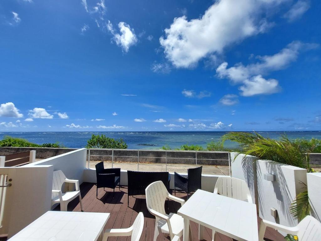 a patio with white tables and chairs and the ocean at Cruz Del Sur - Vacation STAY 11190v in Ishigaki Island