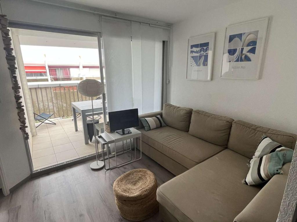un salon avec un canapé et une table dans l'établissement Appartement T2 climatisé à 200m plage, terrasse, parking, 4 couchages - La Grande-Motte - FR-1-250-291, à La Grande Motte