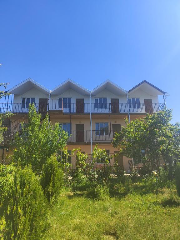 an apartment building with balconies and trees on a hill at У Дяди Жени in Temirovka