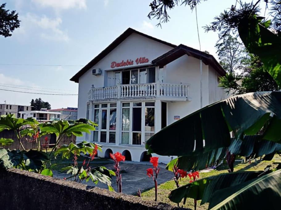 a white building with a sign on it at Holiday Cottage in Ureki, Georgia in Ureki