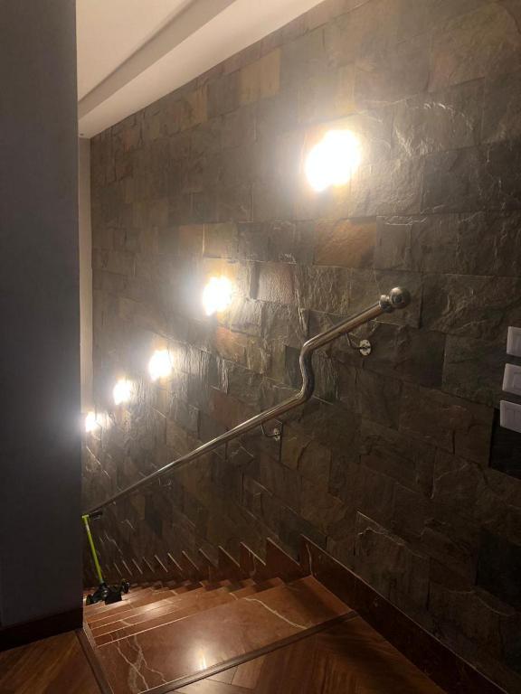 a bathroom with a stone wall with lights on it at Mountain View Hyde park luxury villa in New cairo