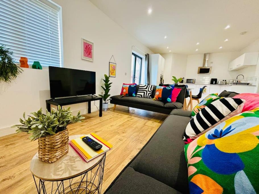 a living room with a couch and a table at Sleeps up to 6 - Central modern - outside space in Gloucestershire
