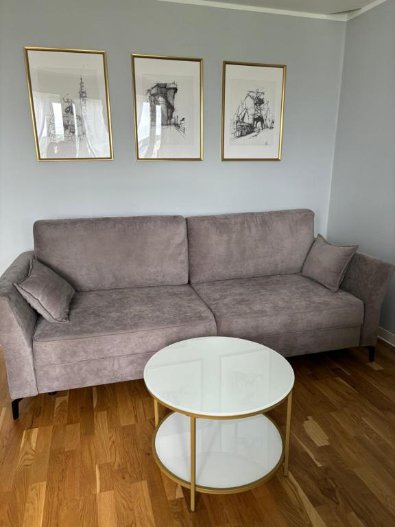 a living room with a couch and a table at Apartament Street Art ZASPA - wśród murali in Gdańsk