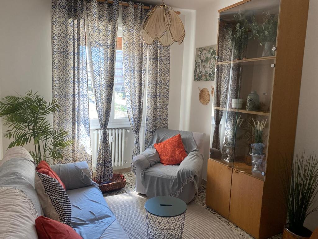 ein Wohnzimmer mit einer Couch und einem Sessel und einem Fenster in der Unterkunft Nebula Nook Luxury Apartment in Modena