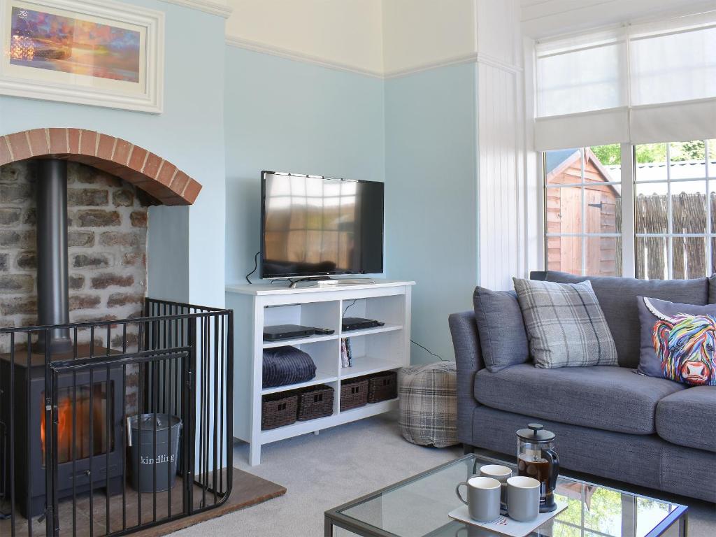 a living room with a couch and a tv at 1 Hamilton Terrace in Lamlash