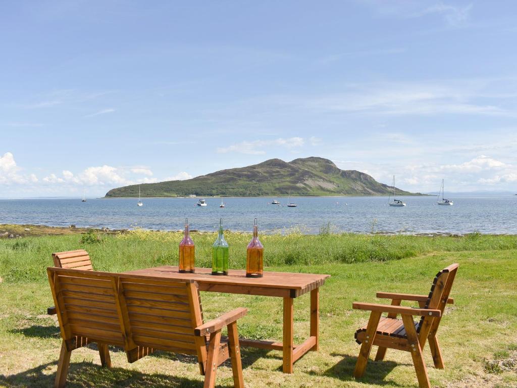a wooden table with two bottles of drinks on it at Kinneil Land in Lamlash