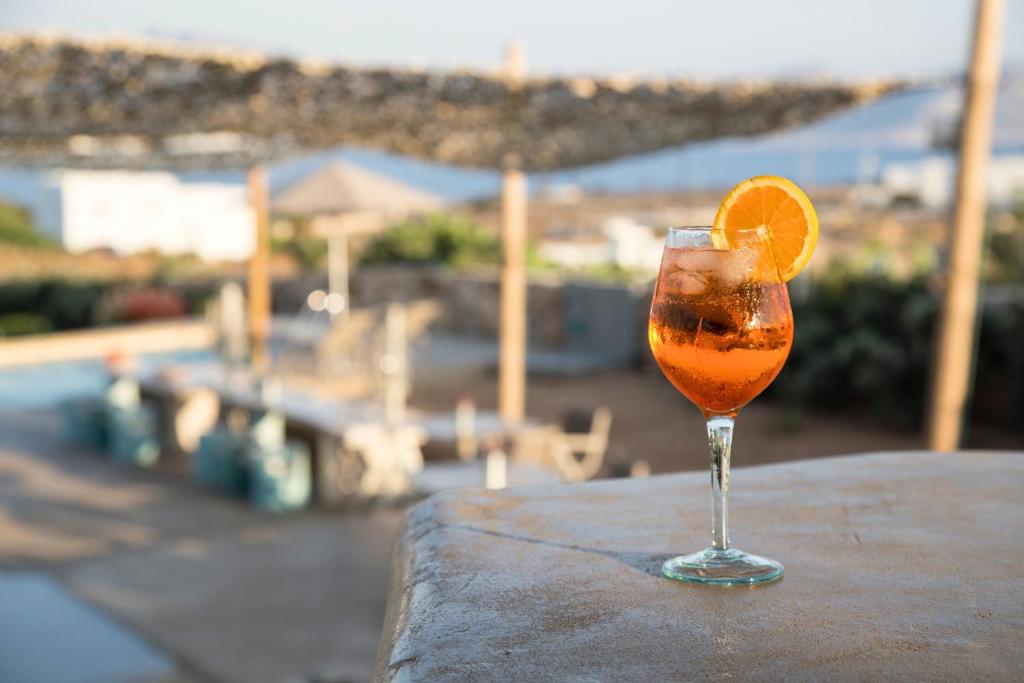 a glass with an orange in it sitting on a table at Portes Houses in Koufonisia