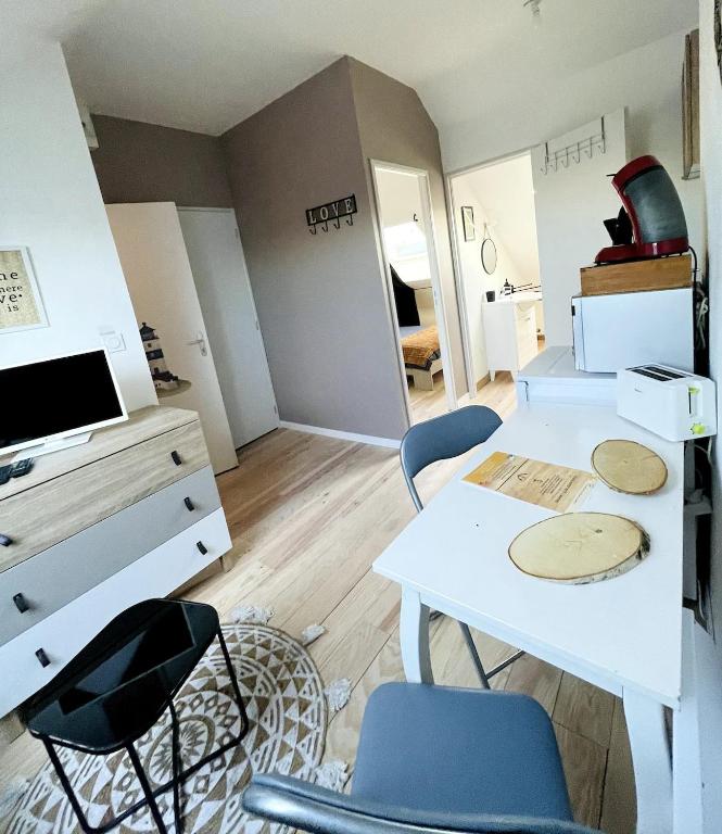 Cette chambre dispose d'une table, de chaises et d'un bureau. dans l'établissement Le phare de la cote ouest, à Saint-Nazaire