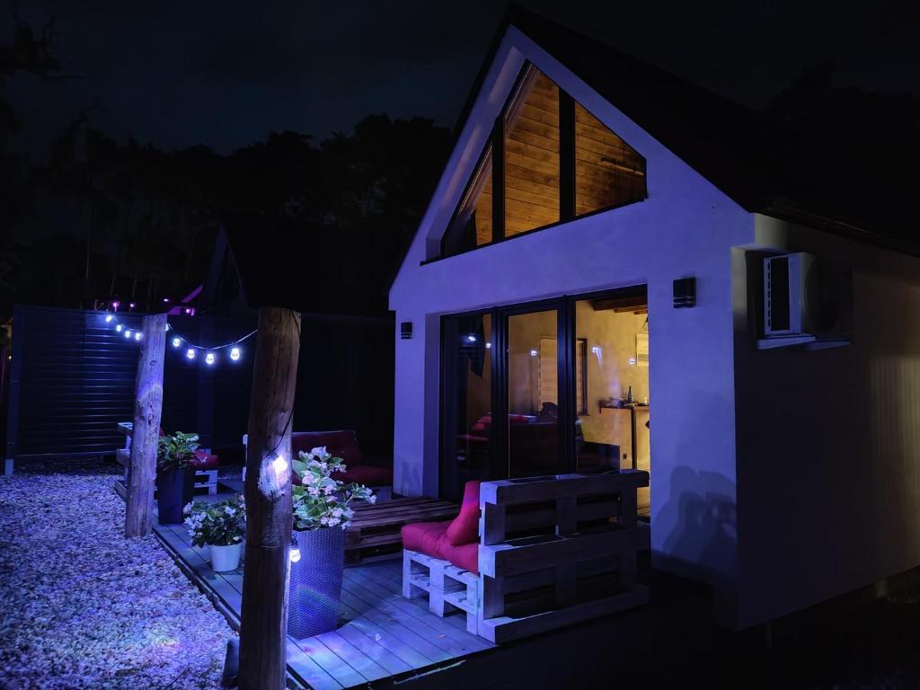 a house with a red chair on a deck at night at Stania Loft CENTRUM in Boszkowo-Letnisko