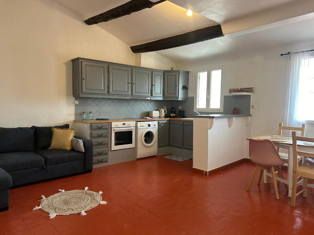 un salon avec un canapé et une cuisine dans l'établissement Namasté, à Aix-en-Provence