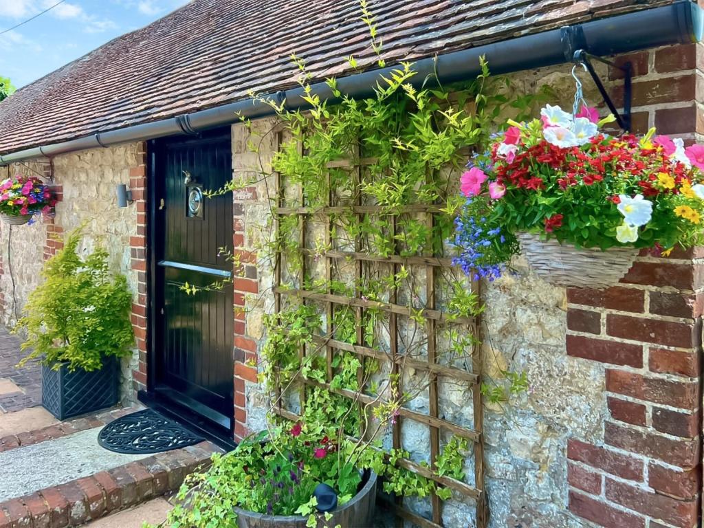 a house with flowers on the side of it at Hop Cottage in Sellindge
