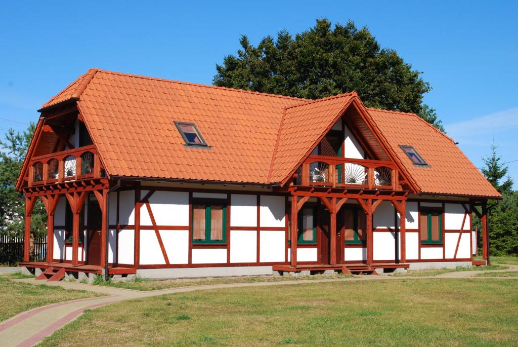 una casa con techo naranja en Apartamenty Mewa, en Jantar