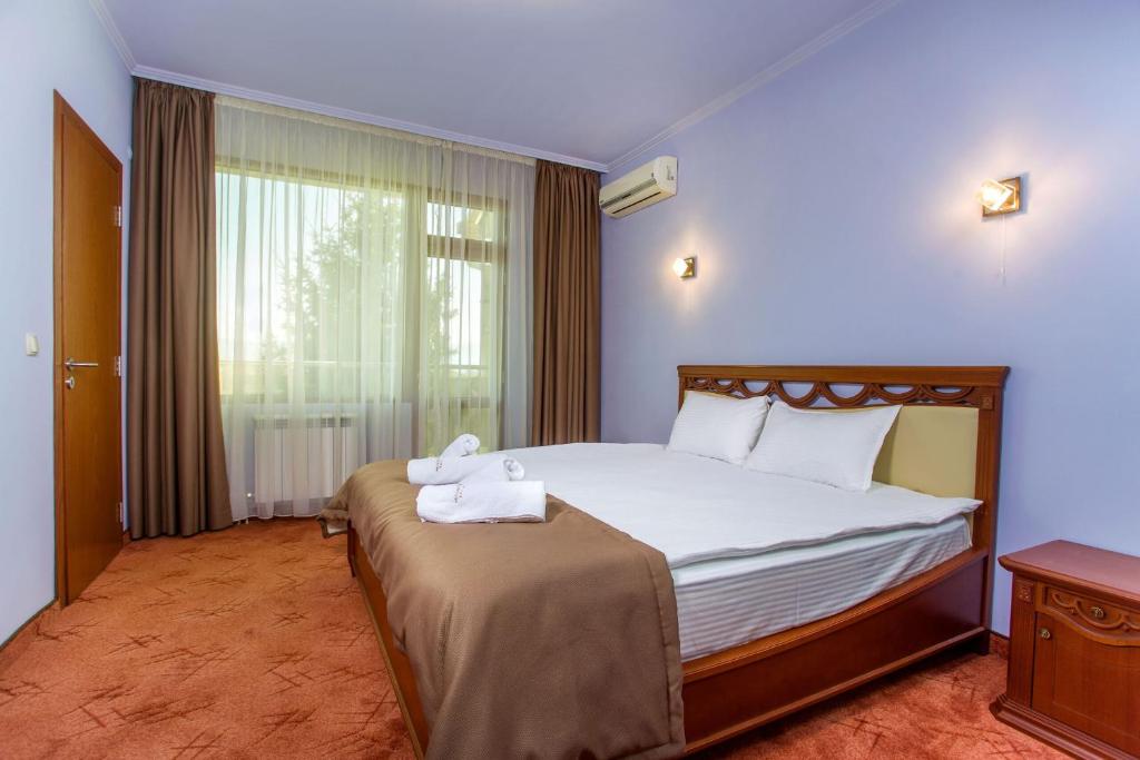 a bedroom with a bed with towels on it at Парк-Хотел Клементина in Trud