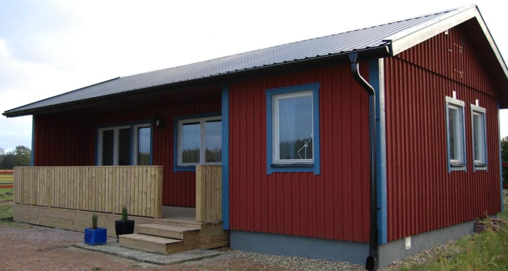una casa roja con techo rojo y ventanas en Bjurmangården Recycled Glass Design en Sjöbo