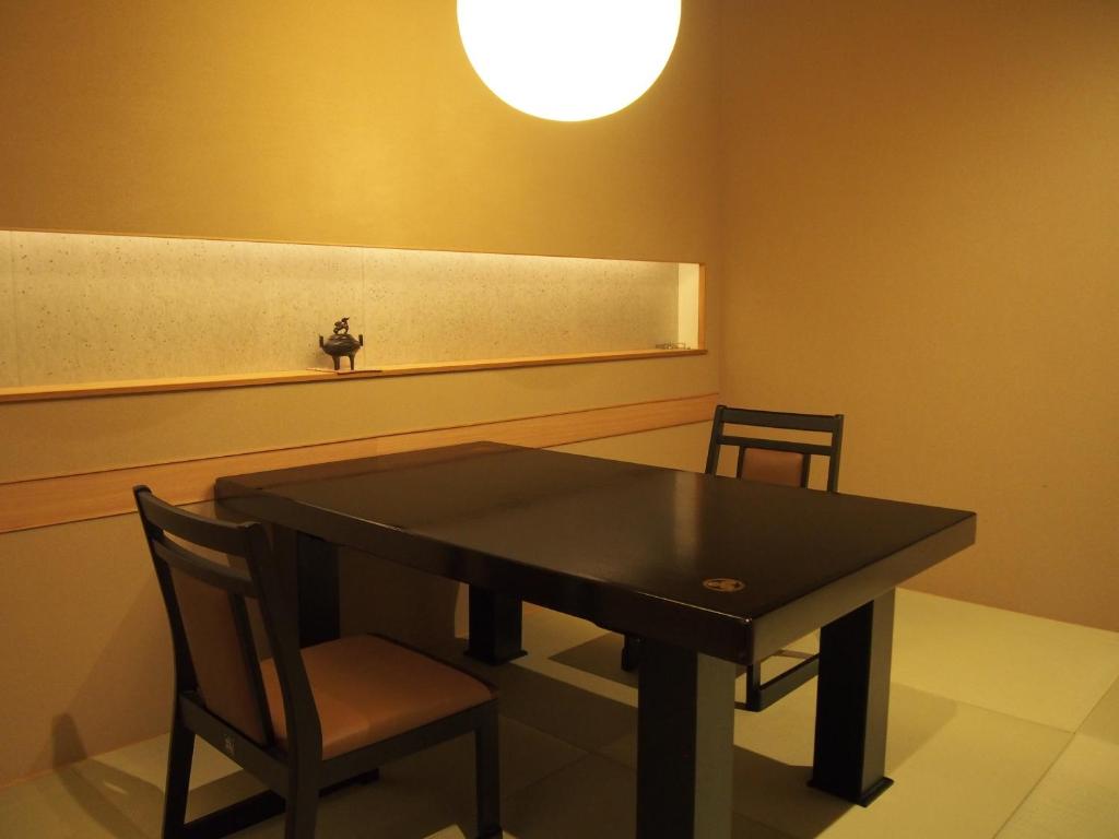 a dining room with a black table and two chairs at Yoshimatsu in Hakone
