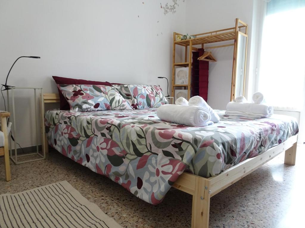 a bedroom with a bed with a flowered comforter at Suite Romeo-monolocale intimo vicino alle spiagge in Grado
