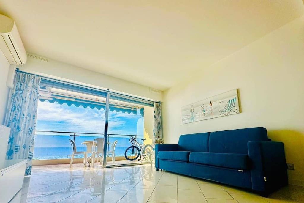 - un salon avec un canapé bleu et une vue sur l'océan dans l'établissement Art de vivre sur la Promenade, à Nice