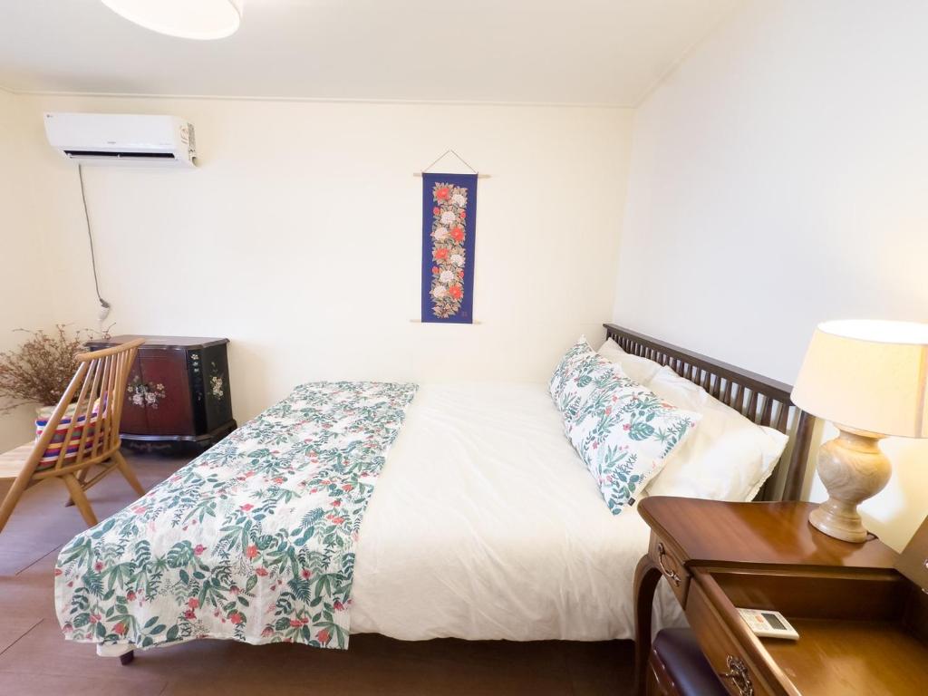 a bedroom with a bed and a table with a lamp at Yunseul- Garden House in the City with Korean Beauty in Seoul
