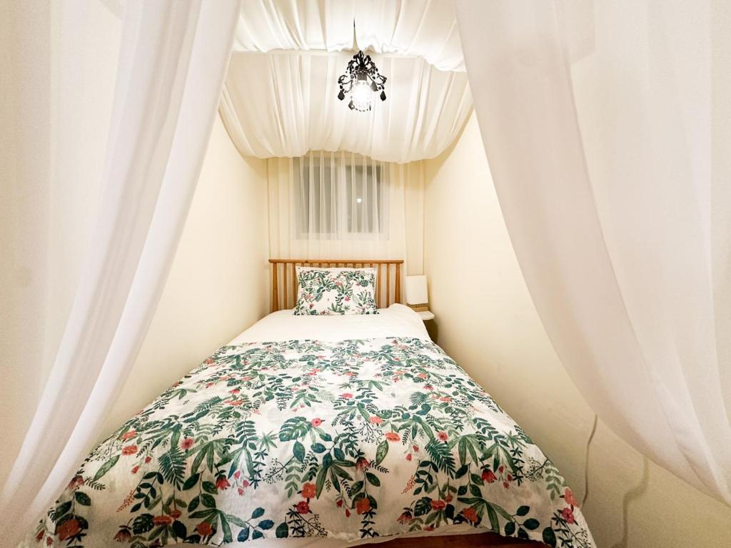 a bedroom with a bed with a floral bedspread at Yunseul- Garden House in the City with Korean Beauty in Seoul