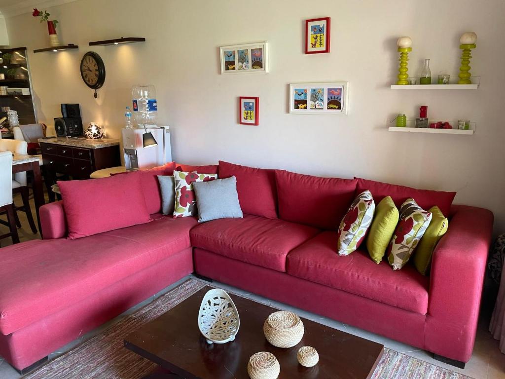 a red couch with pillows on it in a living room at Family-Friendly Chalet at Piacera, Ain Sokhna in Ain Sokhna