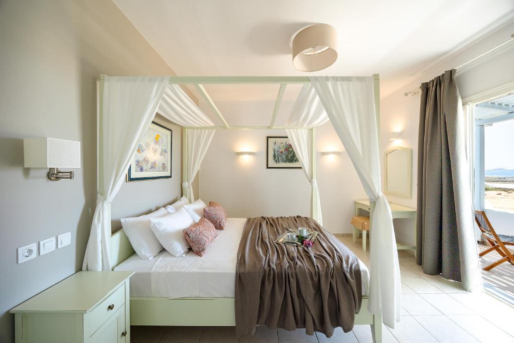 een slaapkamer met een hemelbed bij Villa Porto Rondo in Agios Prokopios