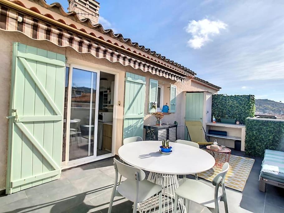 un patio con tavolo e sedie bianchi di Havre cosy et familial, garage, centre ville, dans la cité des Potiers a Vallauris