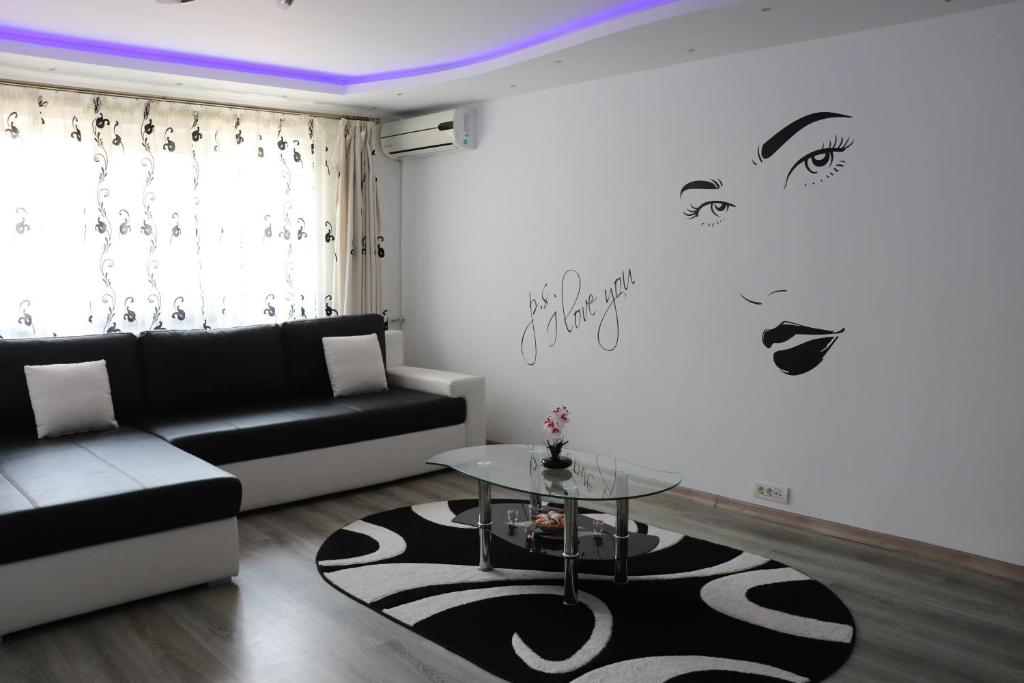 a living room with a black couch and a table at Apartament Bianca in Năvodari