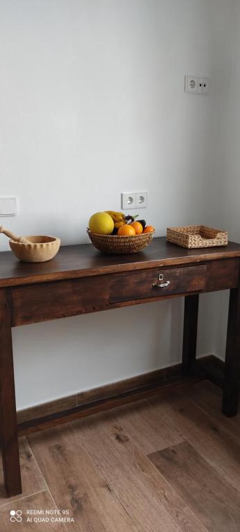 a wooden table with a bowl of fruit on it at Apartamentos Bolonia - M a n u e l a in Bolonia