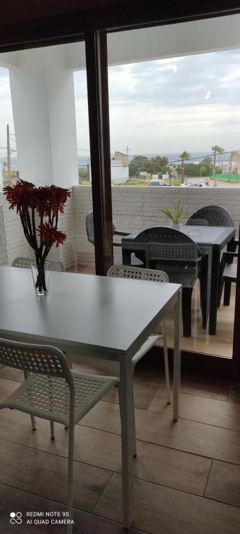 a white table and chairs on a balcony with a view at Apartamentos Bolonia - M a n u e l a in Bolonia