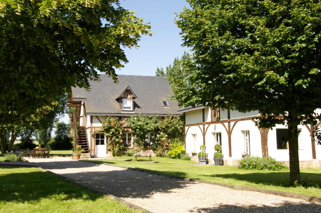 une grande maison blanche avec une pelouse et des arbres dans l'établissement le Clos Saint Lucien, à Saint-Lucien