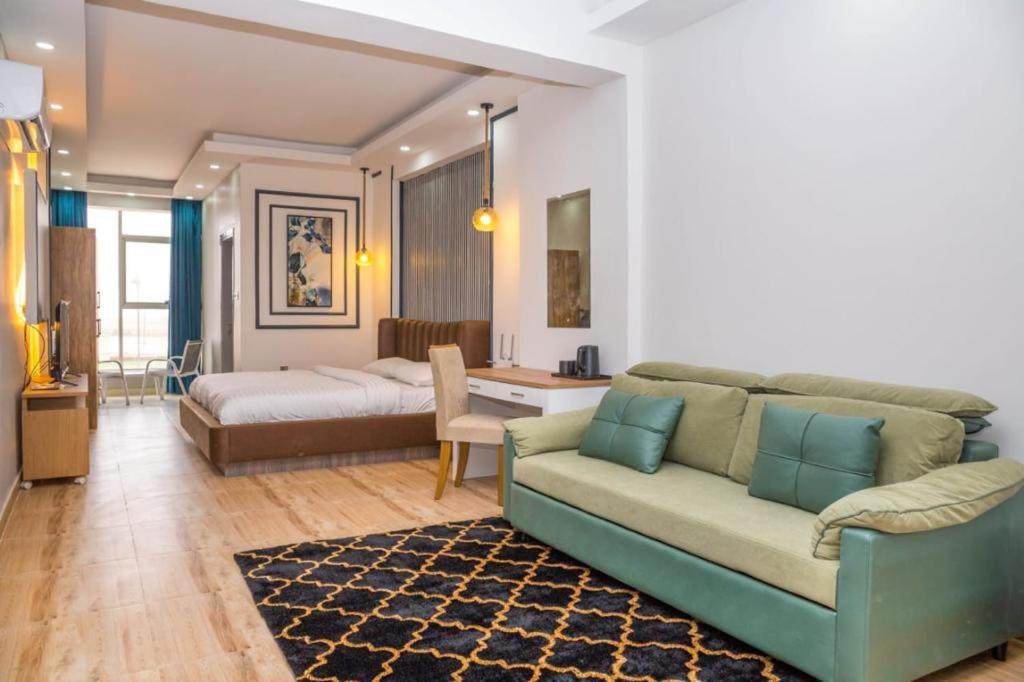 a living room with a couch and a bed at itten plaza blue in Salalah
