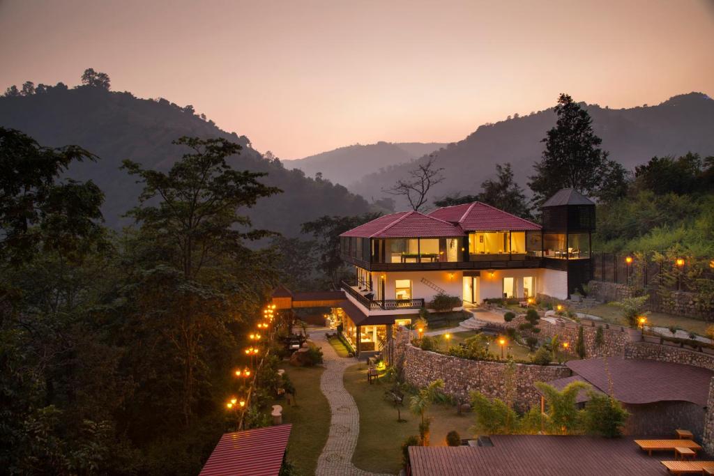 a house in the middle of a mountain at night at Aureva Shaantam Resorts & Spa - Rishikesh in Rishīkesh